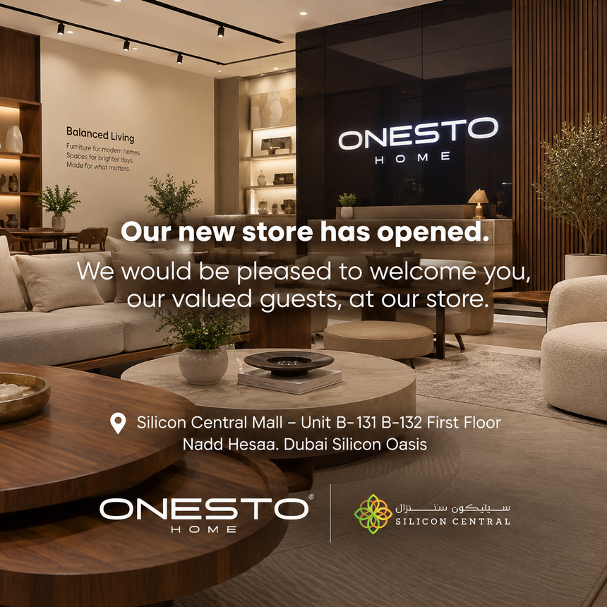 Promotional store opening graphic for ONESTO HOME, showing a modern furnished showroom interior with sofas, coffee tables, plants, and a large ONESTO HOME sign on a black wall. Text reads: 'Our new store has opened.